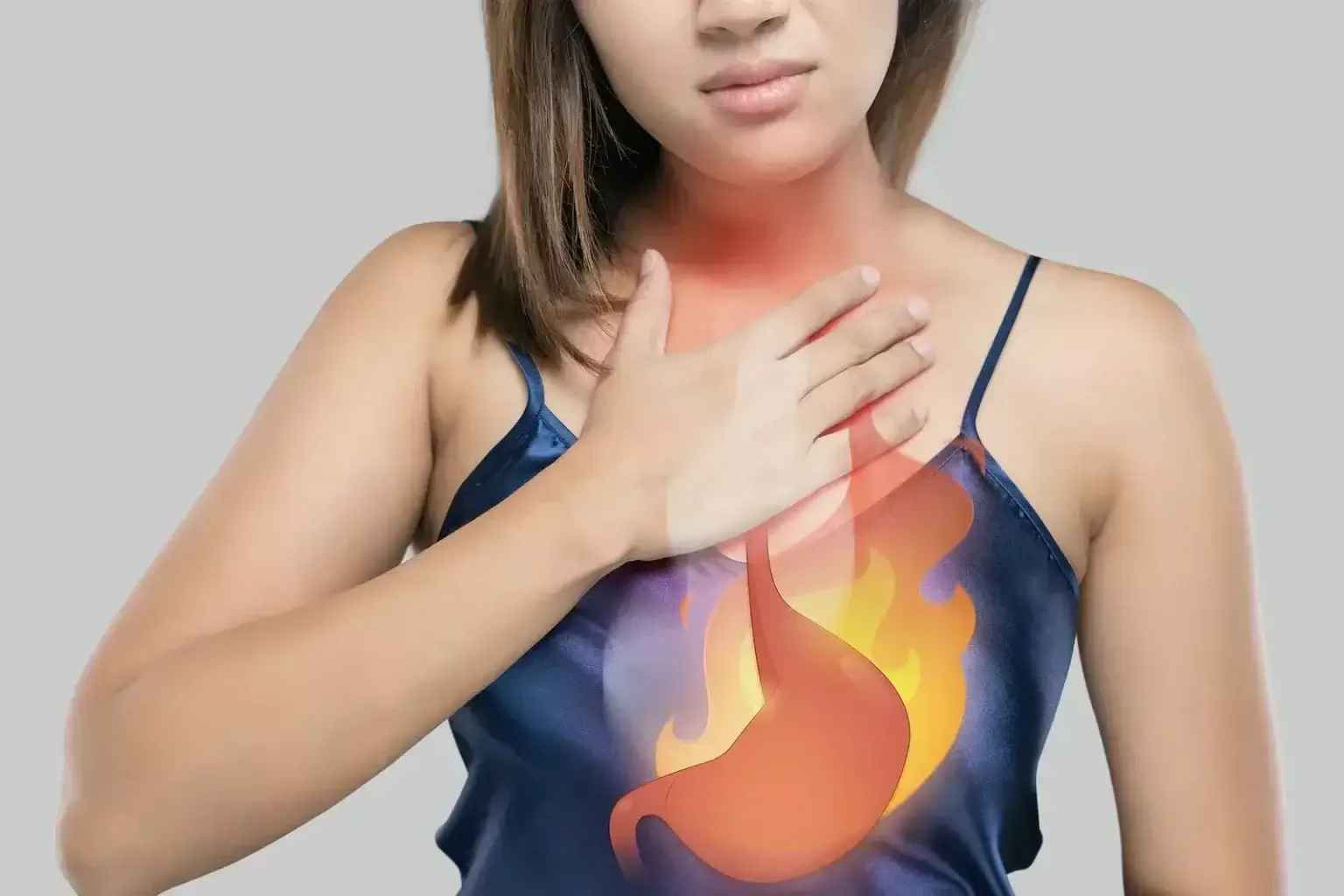 Žena si drží hruď, na hrudi je graficky znázornený plameň a žalúdok, čo symbolizuje pálenie záhy a reflux.