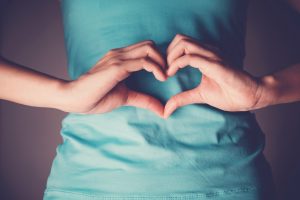 Žena rukami tvorí srdce, čo poukazuje na tráviace enzýmy a ich optimálne fungovanie